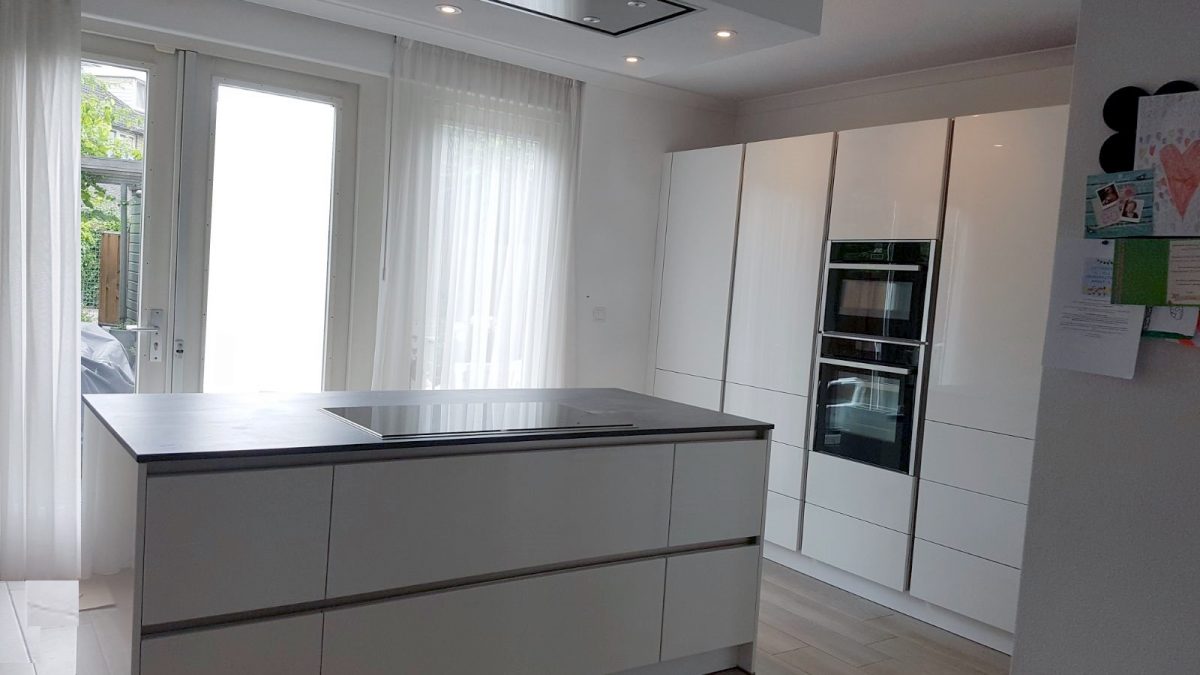 Keuken modern eiland hoogglans wit greeoploos en hoge kastwand met